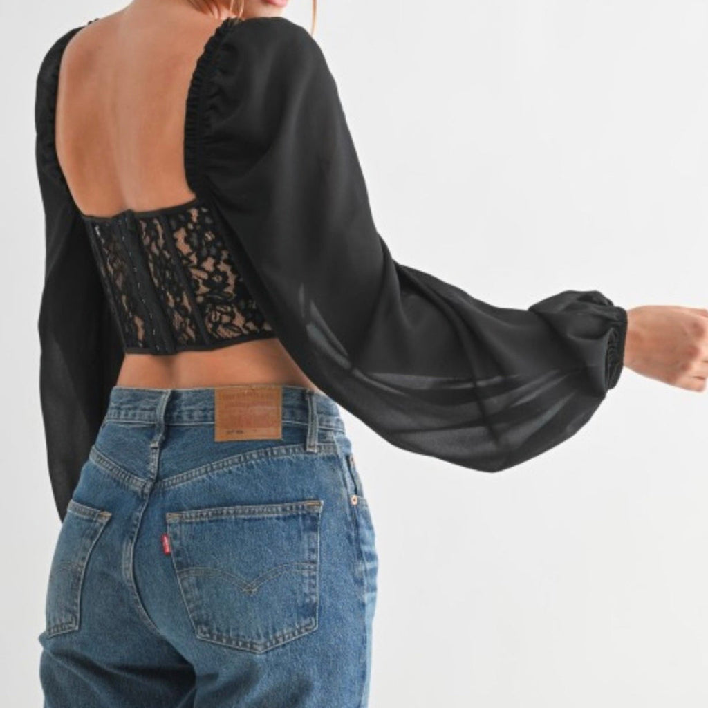 Woman wearing a black blouse with sheer back 