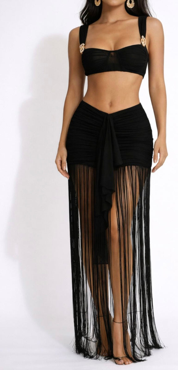 Woman wearing a black bikini with a sheer black skirt on a white background