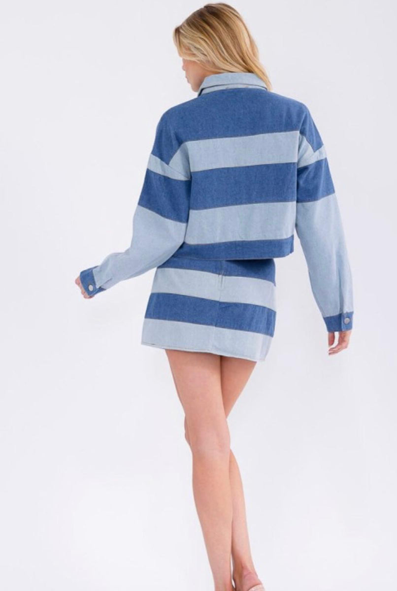 Woman wearing a denim striped jacker and a mini skirt on a white background